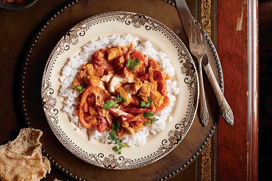 Plato con arroz blanco y por encima pollo Tikka Masala