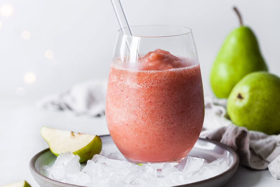 Smoothie de pera en un vaso de cristal con peras de fondo