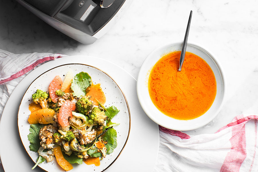 Vinagreta de salsa harissa en un bol junto a una ensalada de coliflor