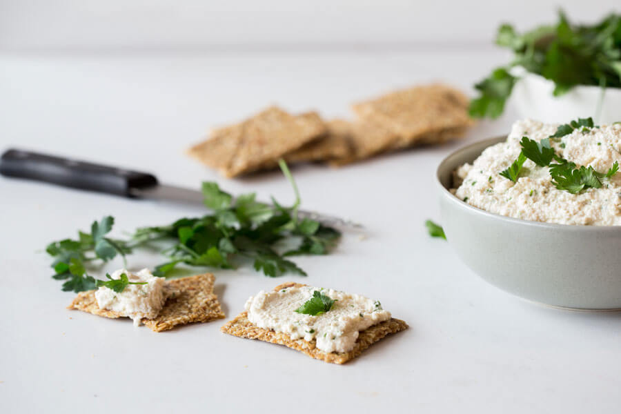 Queso vegano de anacardos en un bol y untado en tostas