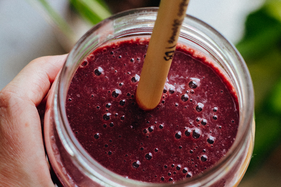 Batido post-entreno de cereza en un vaso con pajita