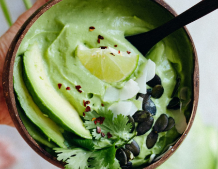 Sopa fría de calabacín y aguacate en un bol de coco