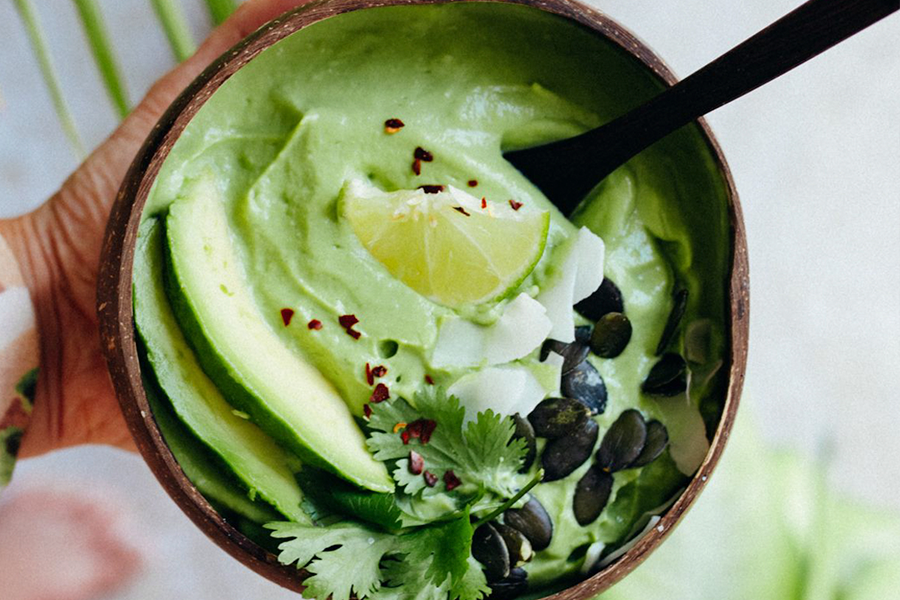 Sopa fría de calabacín y aguacate en un bol de coco