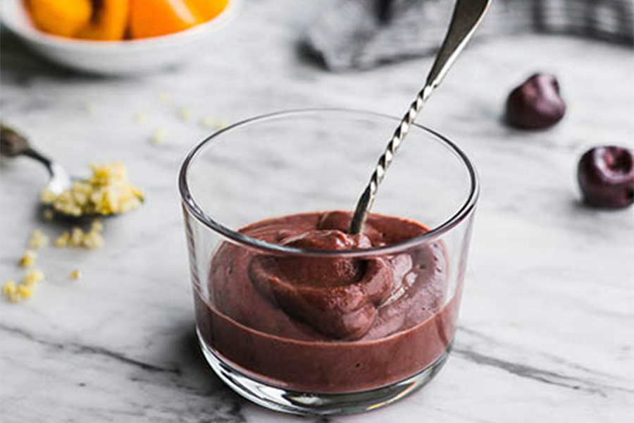 Potito de calabaza, cerezas y mijo en un vaso con cuchara Potito de calabaza, cerezas y mijo en un vaso con cuchara
