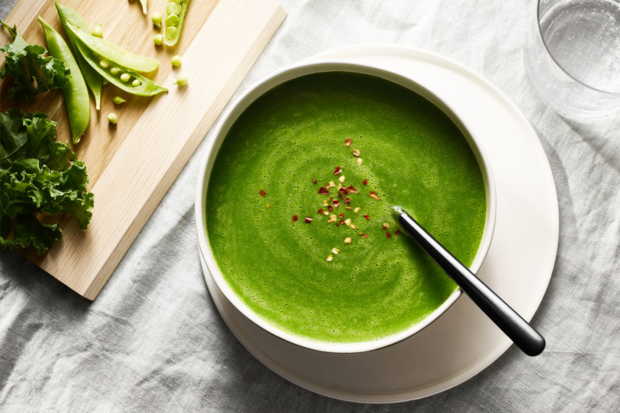 crema de guisantes y col kale servida en un bol