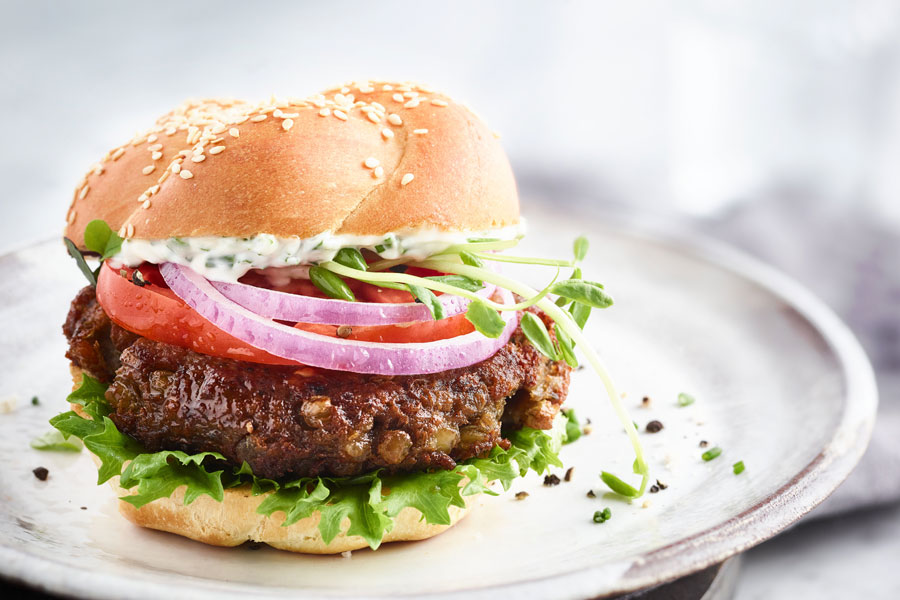 Hamburguesa vegana de lentejas con pan, cebolla, tomate y ensalada. Hamburguesa vegana de lentejas con pan, cebolla, tomate y ensalada.