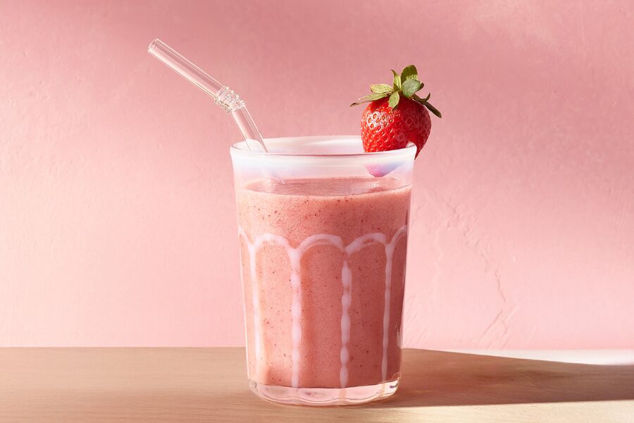 batido de fresa con agua de coco servido en vaso con pajita